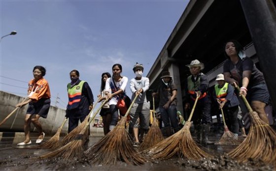 Thai volunteers and city workers sweep an intersection during a cleaning drive after floodwaters receded in Bangkok, Thailand, on Nov. 19. Hundreds of city workers, police, army personnel and civilian volunteers performed the cleaning at various sites which were flooded earlier. 